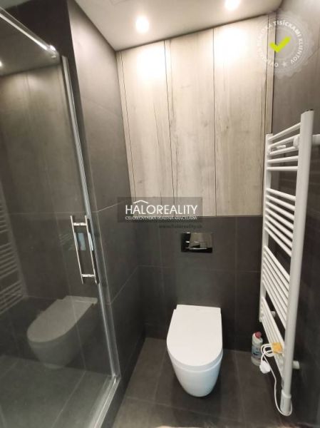 Bathroom sink cabinet in a studio apartment with wood decor and gray tiles.