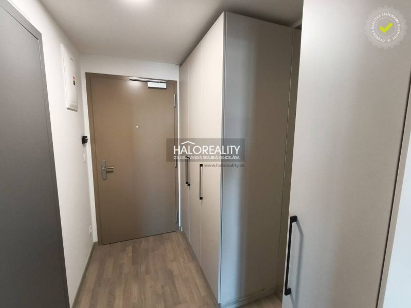 A room with a wooden floor decor and balcony doors in a studio apartment.