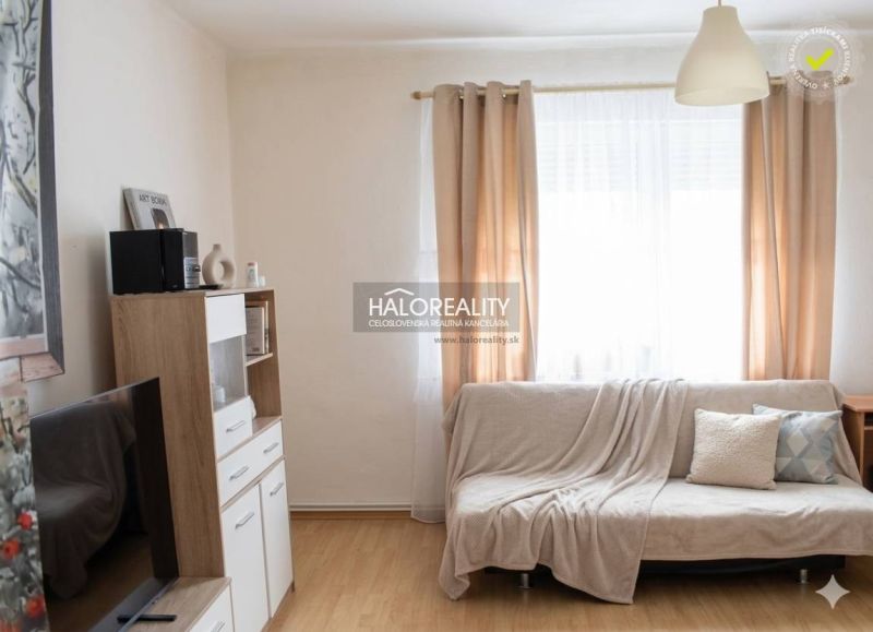 Living room in a family house with a wooden decor floor and light curtains.