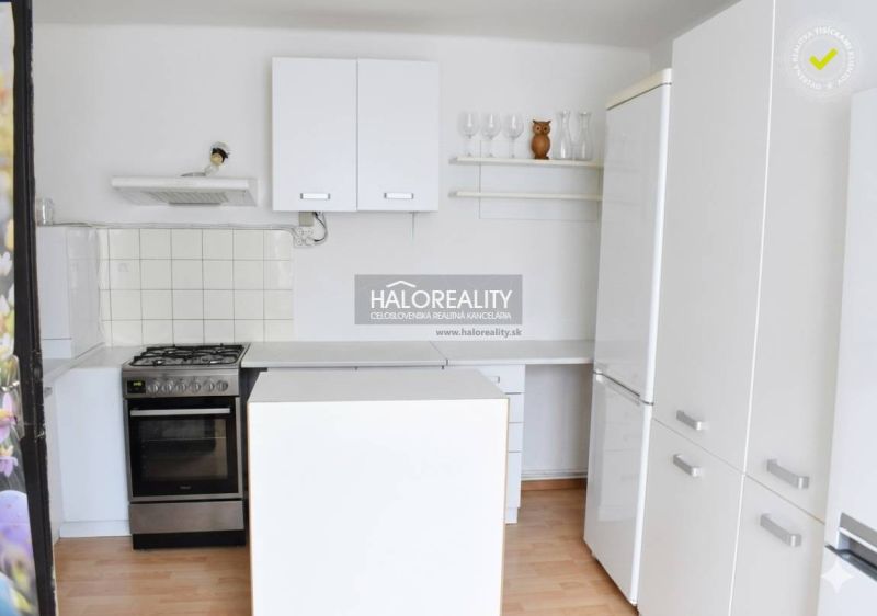 A kitchen in a family house with white cabinets and a wooden decor floor.