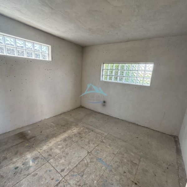 Empty room of a cabin with large glass blocks on two walls.