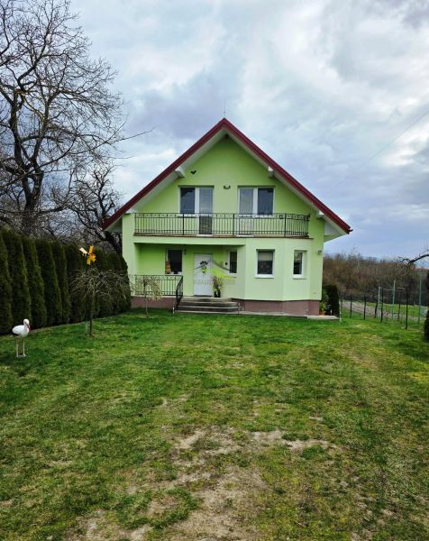 A green family house in Klokočov with a veranda and a landscaped garden.