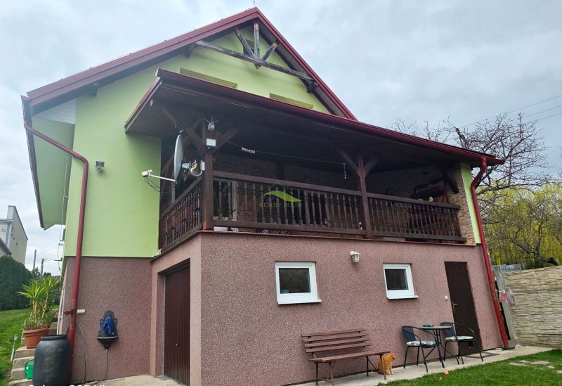 A family house in Klokočov with a covered terrace, greenery, and outdoor furniture.