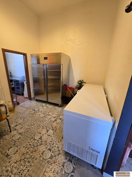 Cooling room with tiles in catering premises, containing a metal cabinet and a freezer.