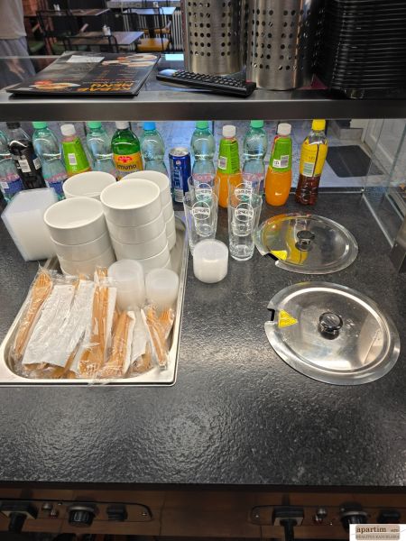 Interior of dining spaces with drinks, glasses, bowls, and cutlery ready for serving.