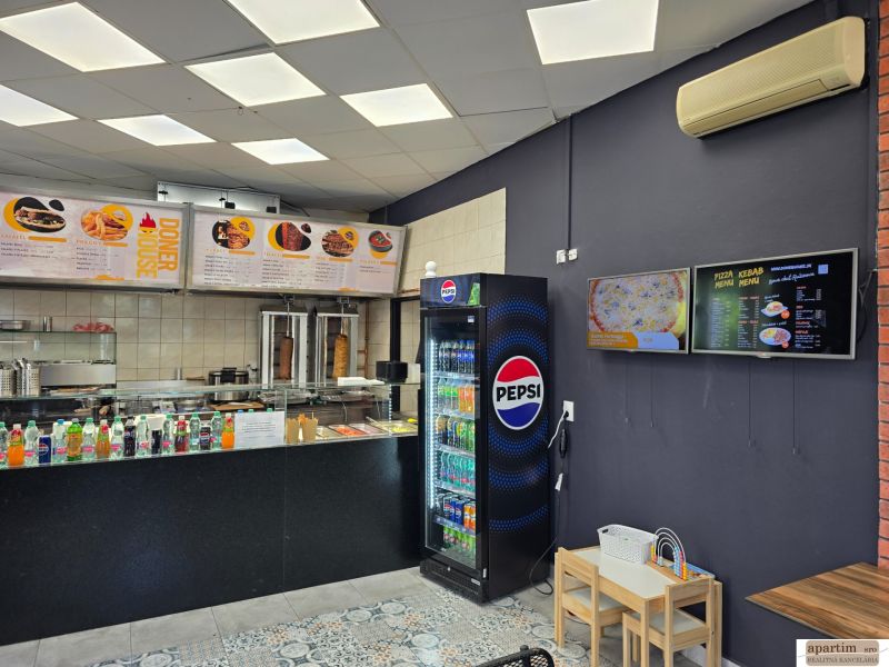 Gastro premises with the sale of drinks and food, floor with wooden decor, menu on the walls.