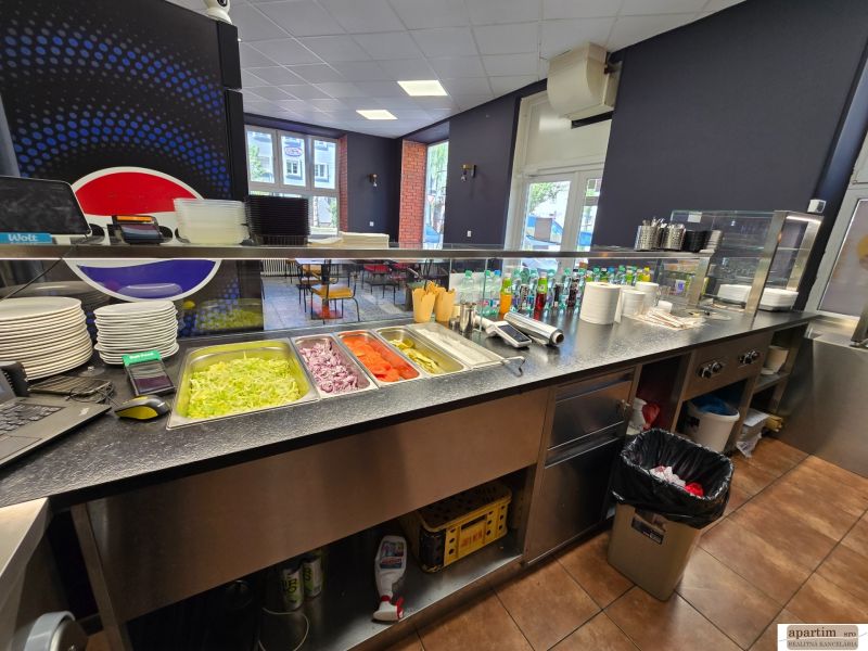 Gastro premises with bowls, vegetables, and drinks on counters and a floor with a wooden decor.