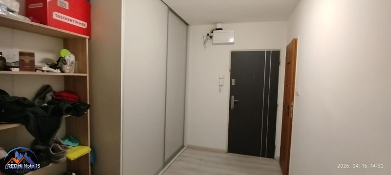 A hallway in a 2-room apartment with a built-in wardrobe and shelves for storage.