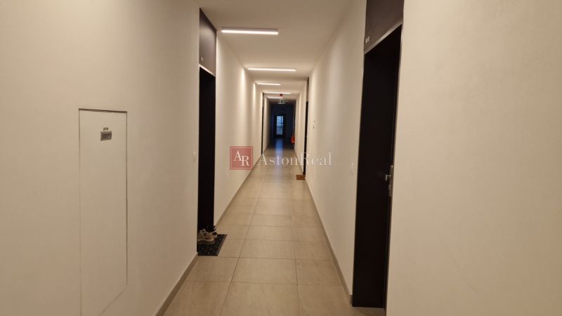 A hallway in a 2-room apartment with a simple interior and tiled flooring.