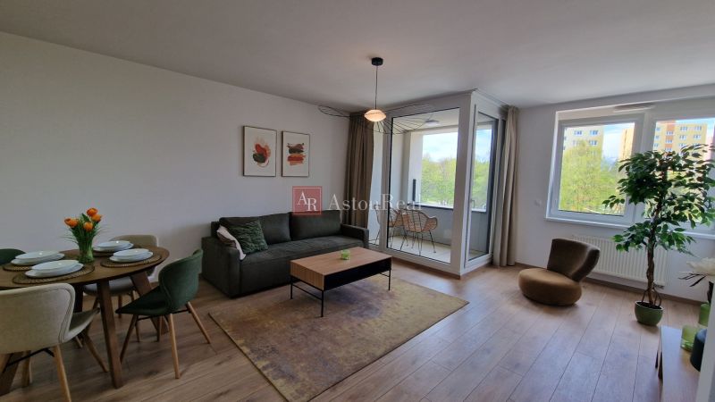 Living room in a two-room apartment with a wooden decor floor and a glazed loggia.