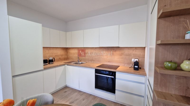A kitchen in a 2-room apartment with a wooden decor and built-in appliances.