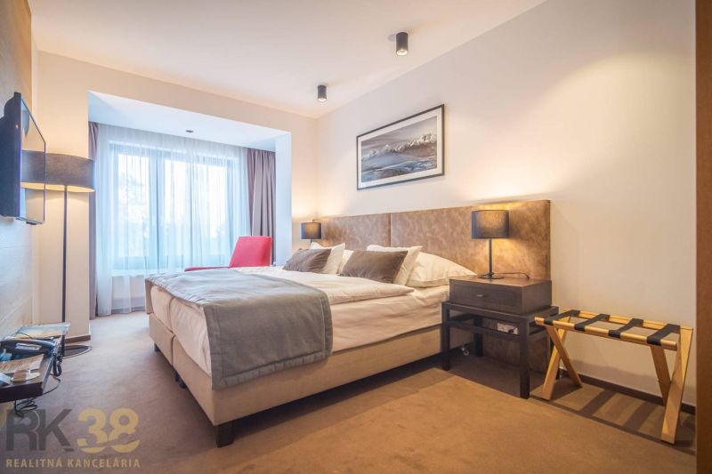 Recreational apartment with a comfortable bed, red armchair, and soft lighting.
