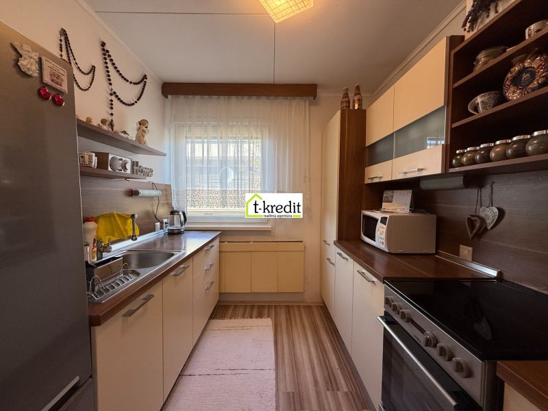 A kitchen in a family house with a wooden decor floor and white cabinets.