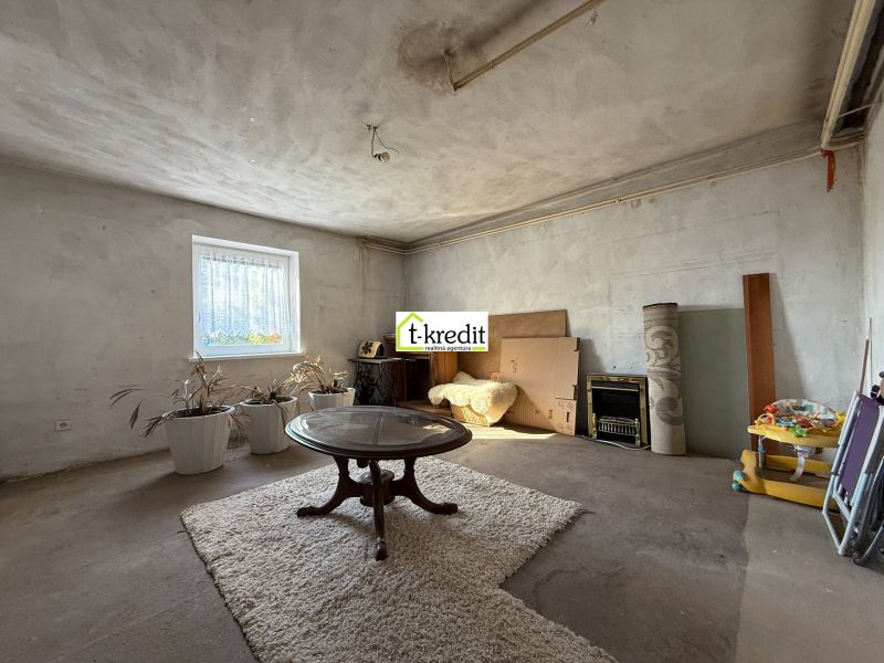 Living room of a family house with an oval table and a carpet on the floor.