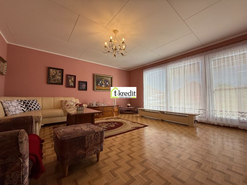 Living room in a family house with a wooden decor floor and comfortable seating.