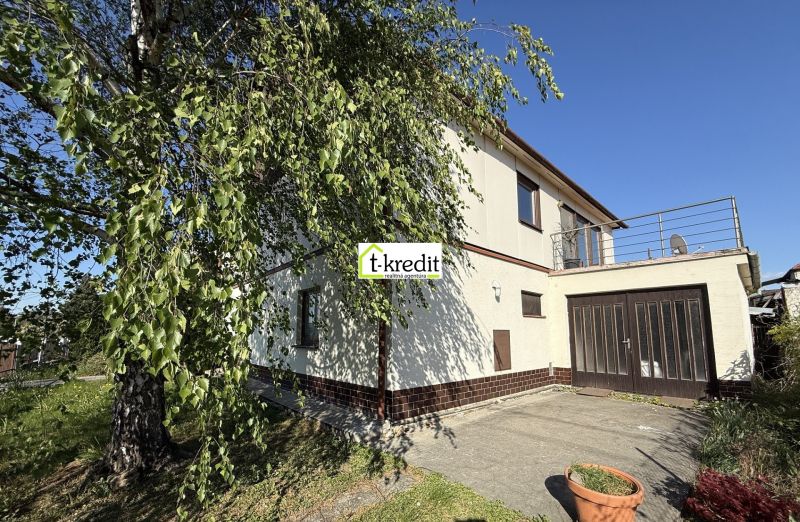 A family house in Zlaté Moravce with a garage and a terrace, surrounded by greenery and trees.
