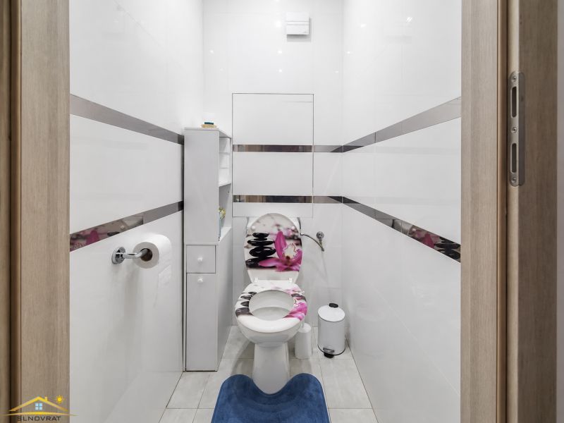 A bathroom in a 3-room apartment with white walls and a white toilet.