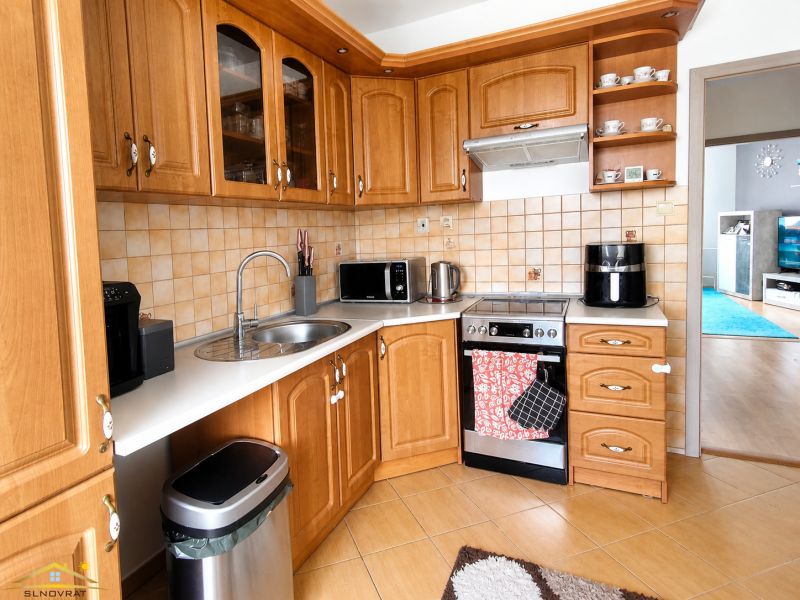 A kitchen in a 3-room apartment with wooden decor and appliances.