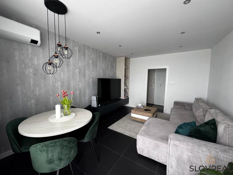 Living room in a three-room apartment with a comfortable sofa and a dining table.