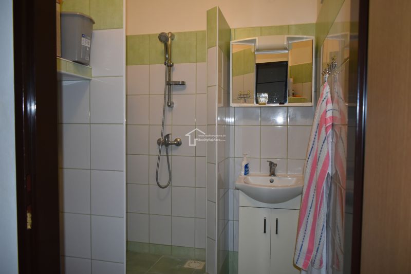 Bathroom in a 3-room apartment with tiling and a shower.