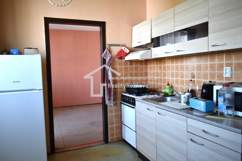 A kitchen in a 3-room apartment with tiled walls and a wooden decor floor.