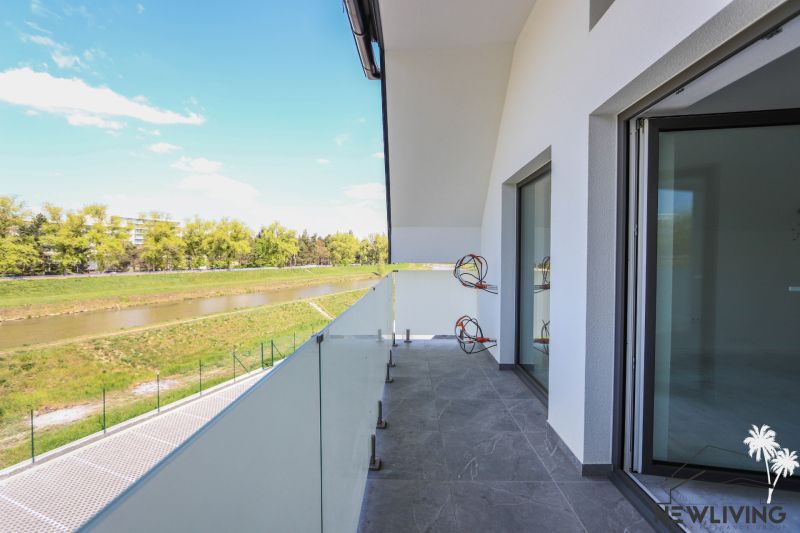 A balcony with a view of the river from a 4-room apartment, glass railing.