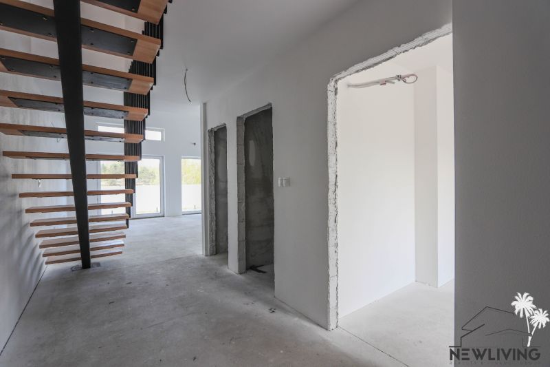 Interior of a 4-room apartment with a staircase and large windows, neutral wall colors.