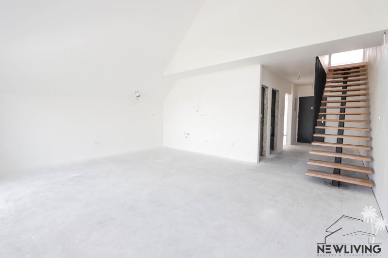 Interior of a 4-room apartment with a concrete floor and wooden staircase.
