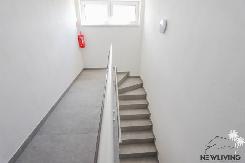 A staircase with a simple railing and windows in a 4-room apartment.