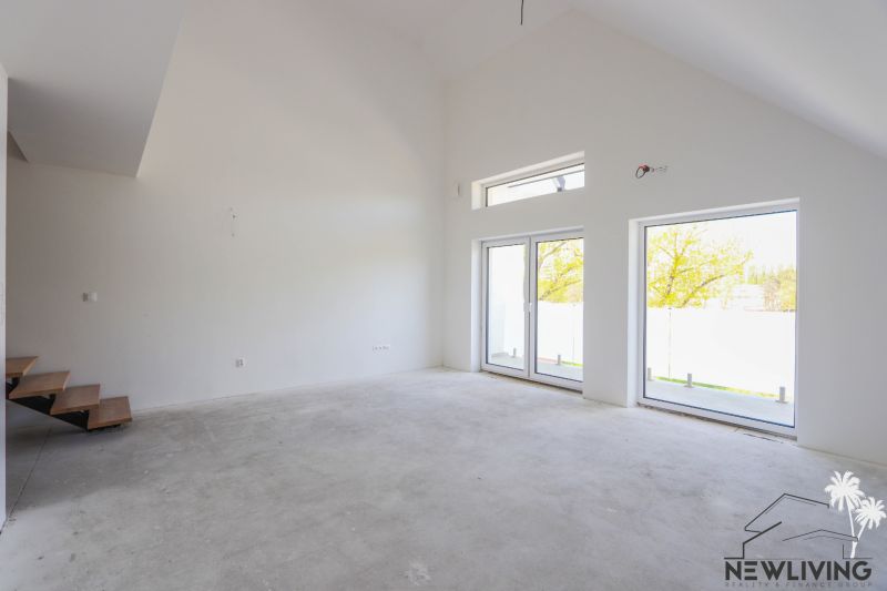 Interior of a 4-room apartment with an empty room, large windows, and stairs with a wooden decor.