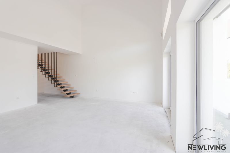 A spacious living room with a staircase and large windows in a 4-room apartment.