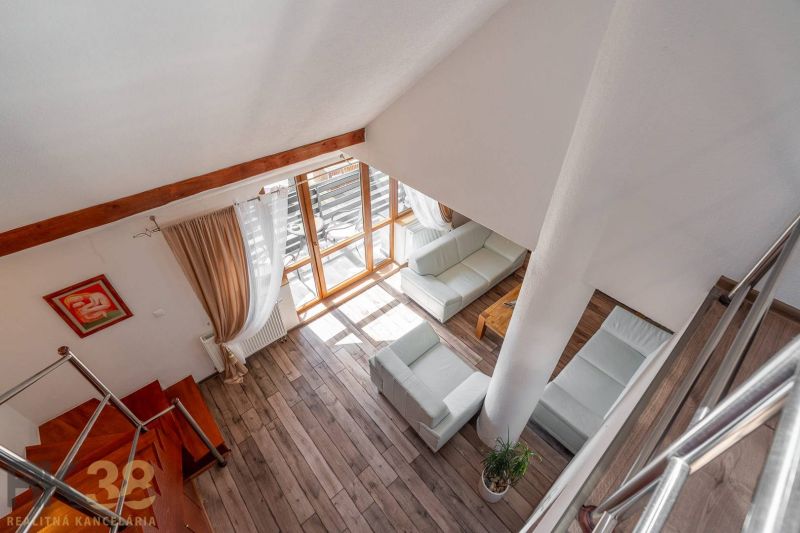 Living room with wood-patterned flooring, staircase, and large windows in a 4-room apartment.