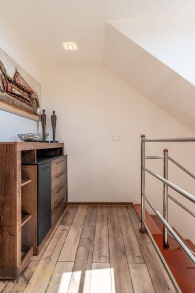 Interior of a 4-room apartment with a wooden decor floor, metal railing, and decorations.
