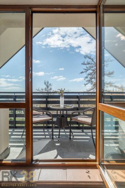 A balcony with a table and chairs in a 4-room apartment in Vyšné Hágy.