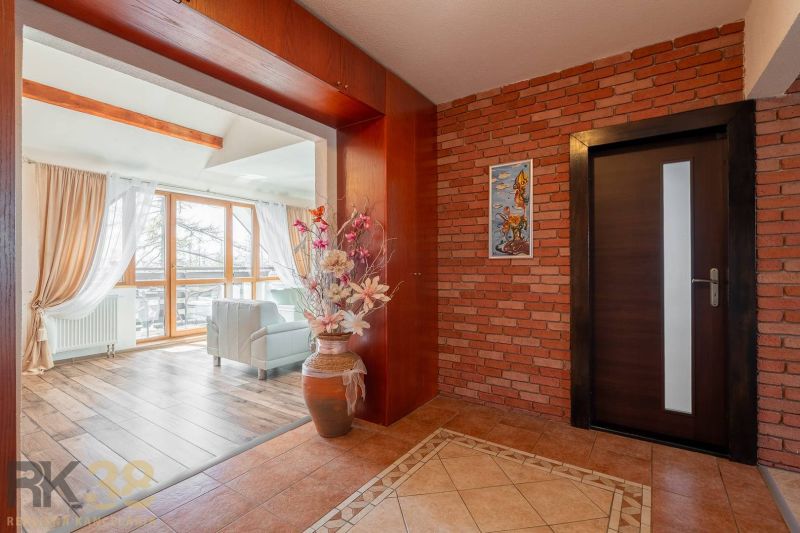 Interior of a 4-room apartment with a brick wall, wood-patterned flooring, and large windows.