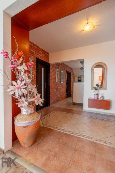 Interior of a 4-room apartment with ceramic flooring, brick cladding, and decorative greenery.