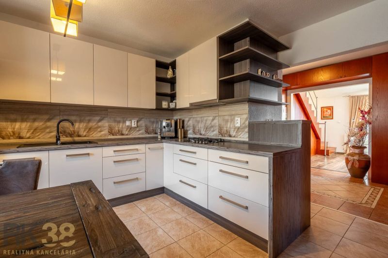 A kitchen in a 4-room apartment with a wooden decor floor and interesting lighting.