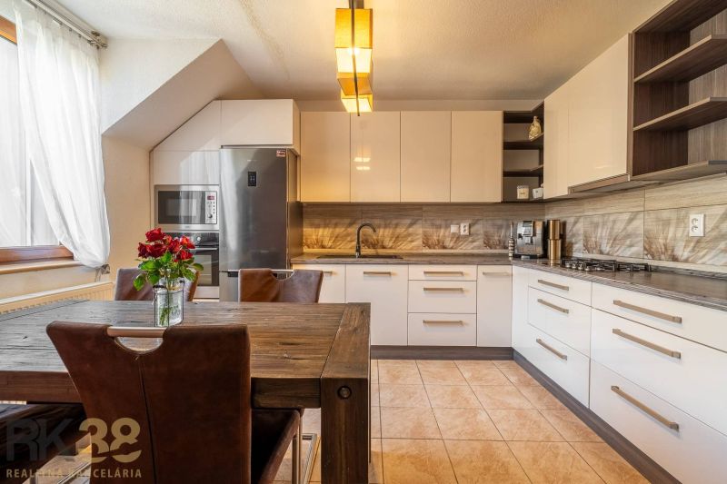A modern kitchen with a dining table in a 4-room apartment with flowers on the table.