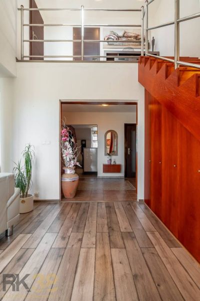 Interior of a 4-room apartment with a wooden decor floor and staircase.