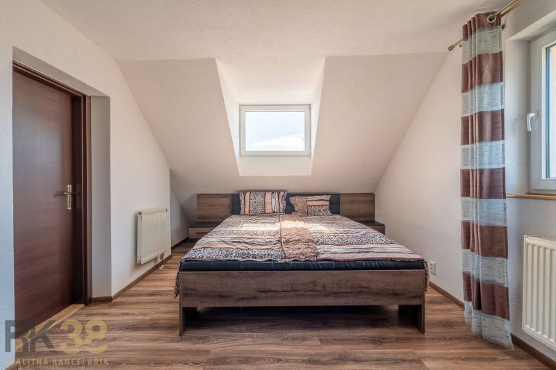 A stylish bedroom with a large bed and a wooden decor floor in a 4-room apartment.