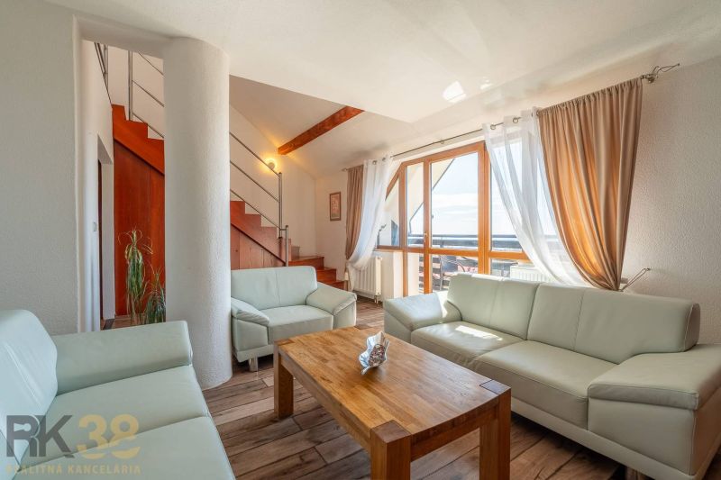 Living room with a light sofa, stairs, and a floor with a wood decor in a 4-room apartment.