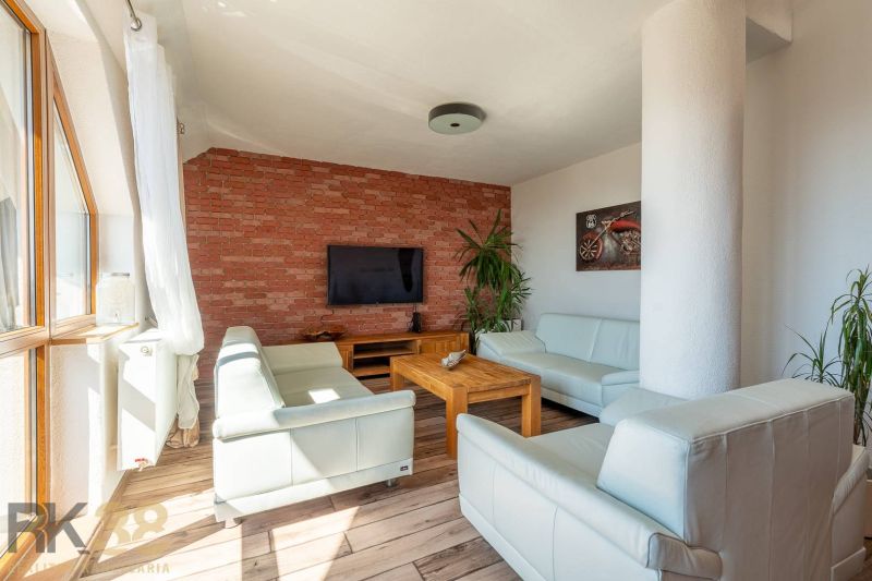 Living room in a 4-room apartment with a brick wall and a floor with a wooden decor.