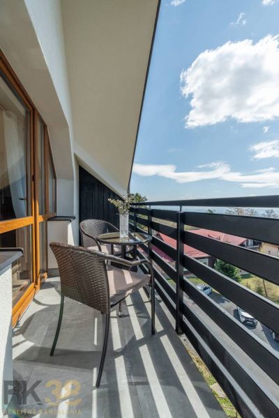 A balcony with rattan seating and floral decorations in a 4-room apartment in Vyšné Hágy.