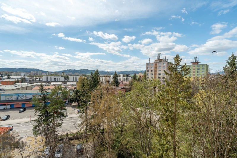 A view of apartment buildings surrounded by greenery and Partizánska Street in Poprad.