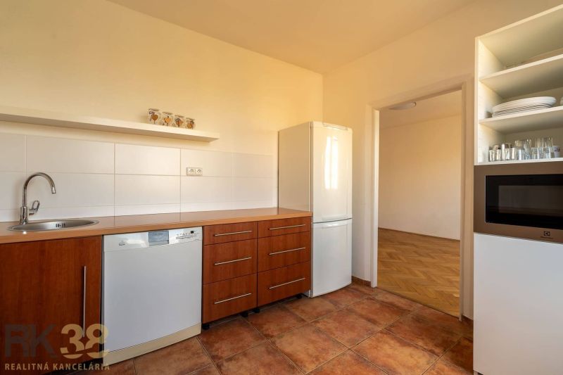 A kitchen in a 4-room apartment with a wood-patterned floor and built-in appliances.