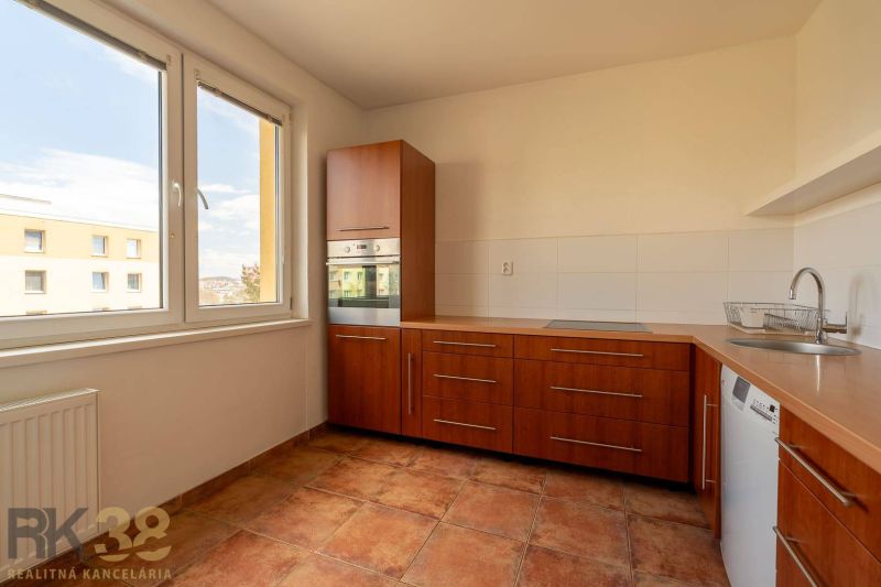 A kitchen unit in a 4-room apartment with a large window and built-in appliances.
