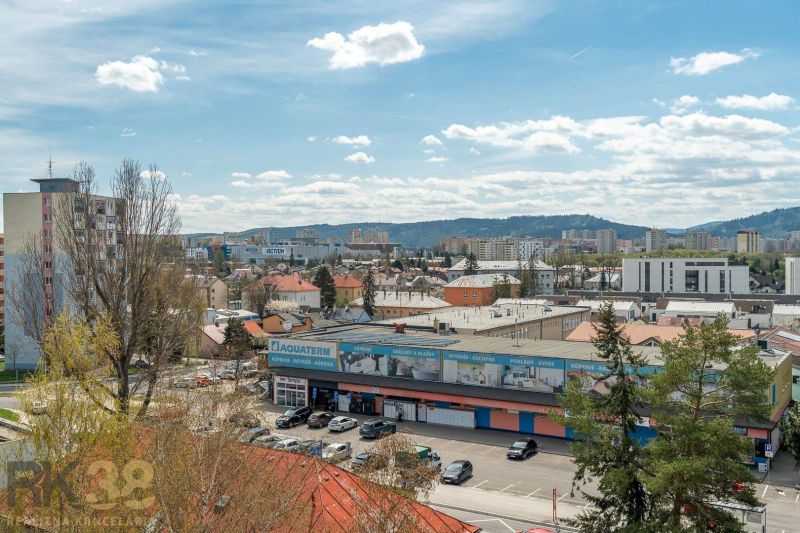 A view of Poprad from Partizánska Street shows 4-room apartments and a crowded parking lot.