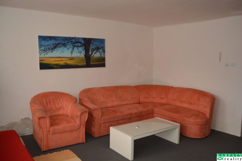 An orange sofa set and a painting in the living room of a family house.