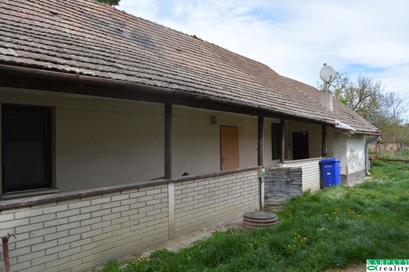 The exterior of a family house in Horné Saliby with a gable roof and brick cladding.