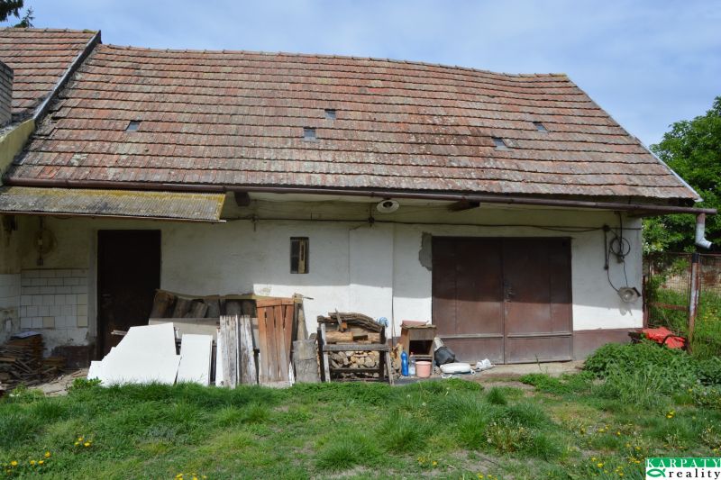 A family house in Horné Saliby with an old roof and an unmaintained exterior space.